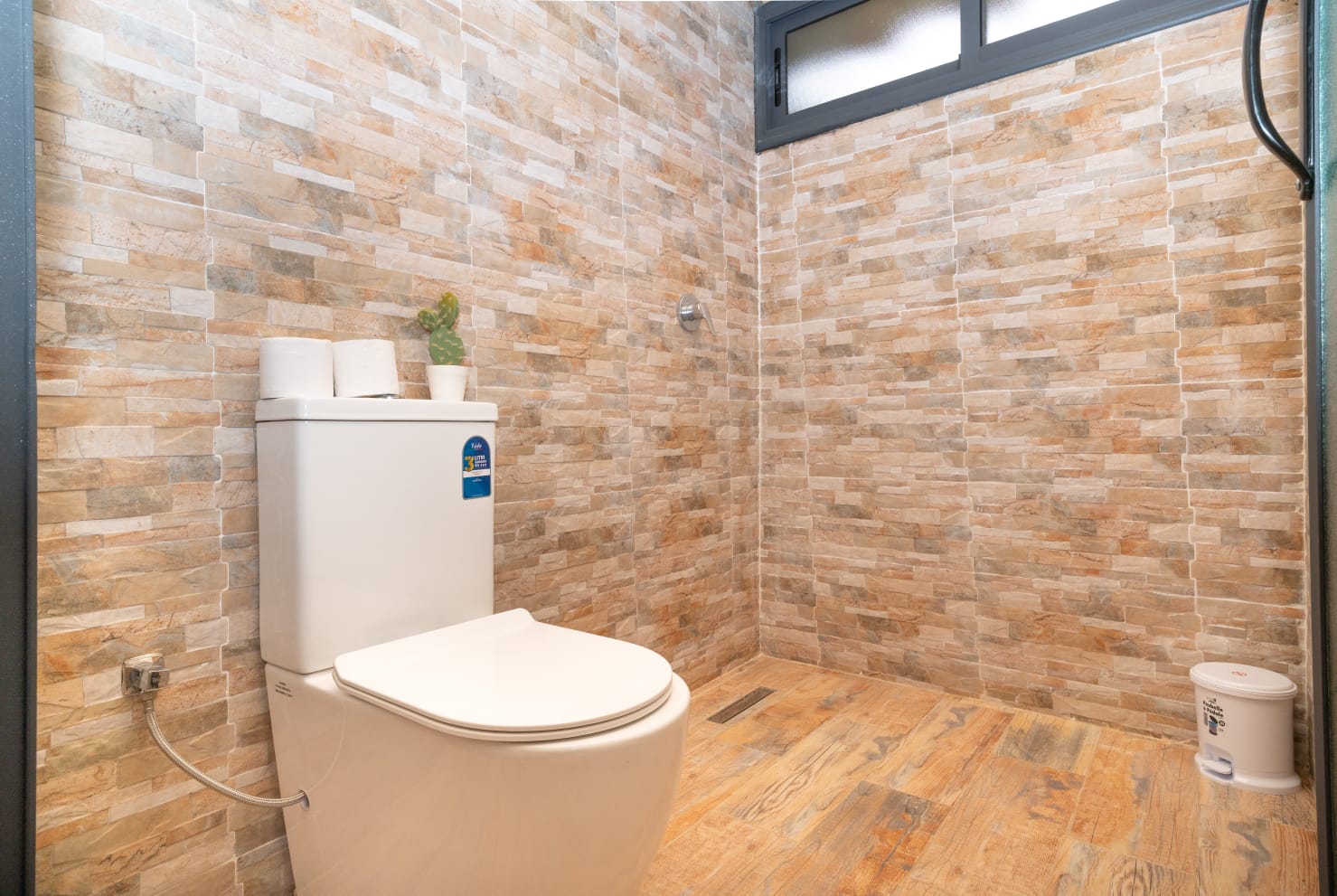Bathroom with marble tiling, walk-in shower and folded towels