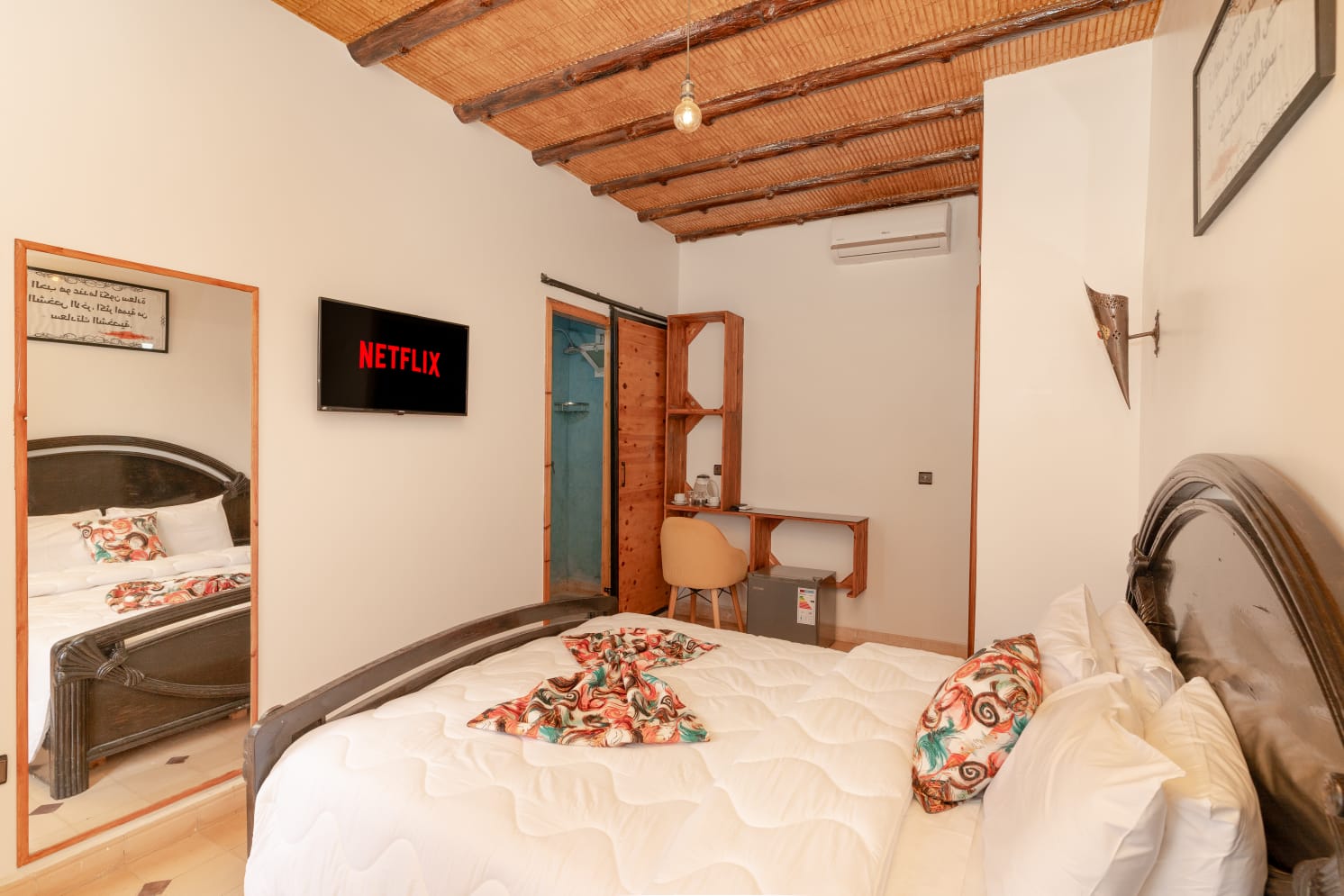 Room with a carved Moroccan bed and reed ceiling detail