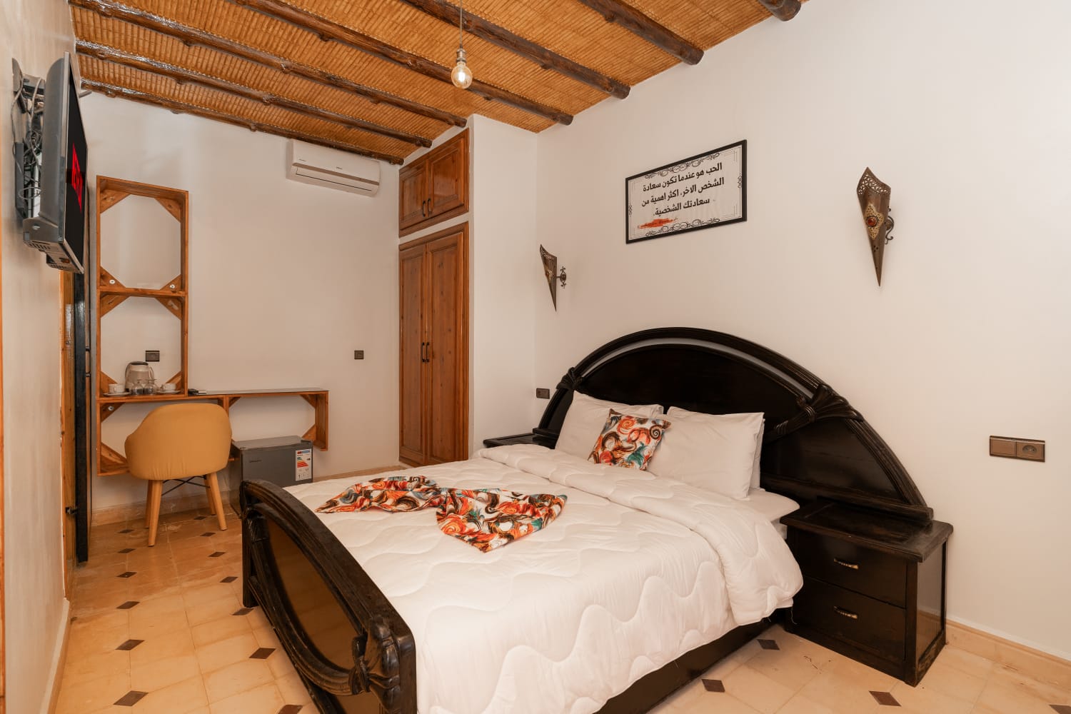 Traditional Moroccan bedroom with dark carved bed frame